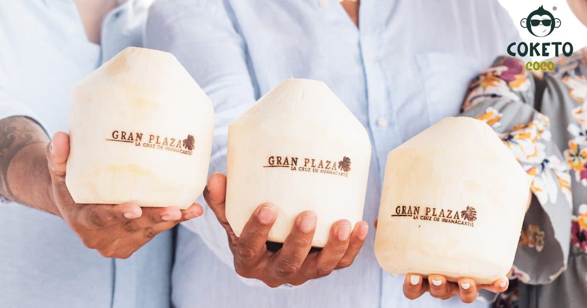Clientes de Gran Plaza sosteniendo cocos Coketo personalizados